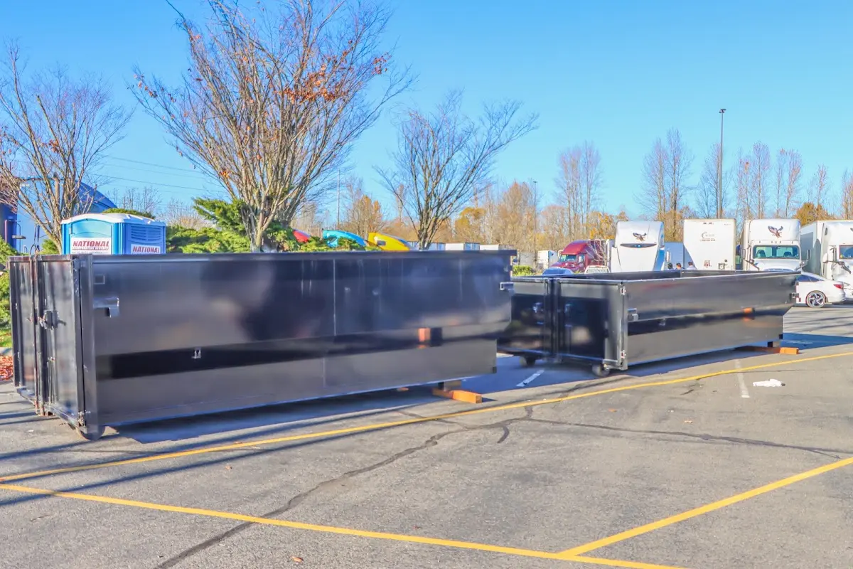 Professional dumpster rental service with roll-off container on residential driveway in Big Rapids